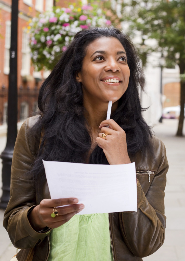 thoughtful woman holding paper.